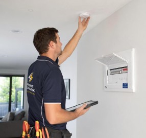 man inspecting fire alarm
